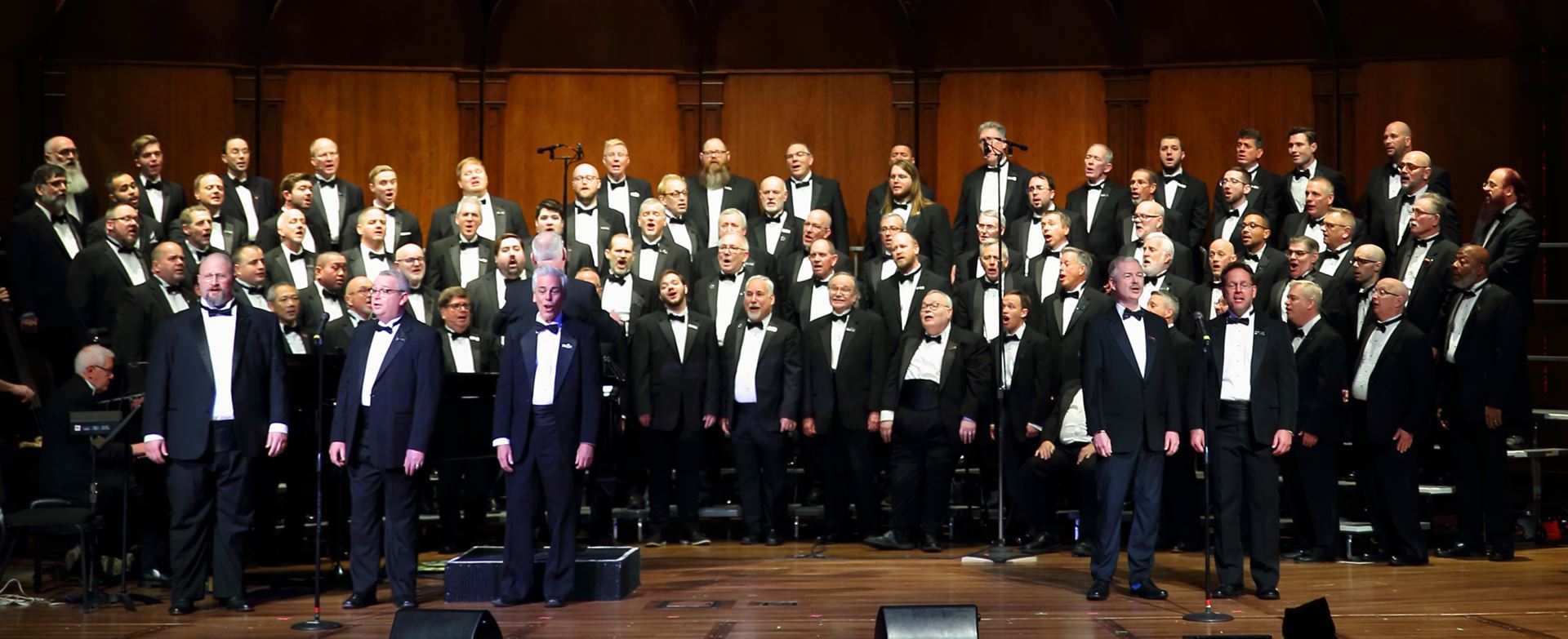 North Coast Men's Chorus on stage in tuxedoes